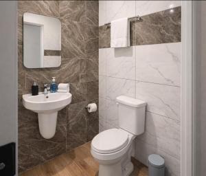 a bathroom with a white toilet and a sink at Pinnacle Apartment Lekki in Lekki
