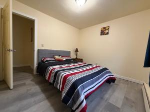 a bedroom with a bed with a striped blanket at Cozy Place in Anchorage
