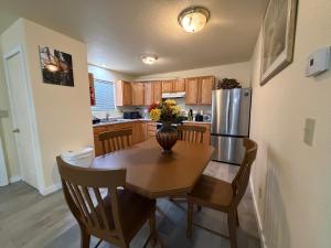 a kitchen with a wooden table and a refrigerator at Cozy Place in Anchorage
