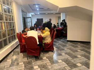 a group of people sitting at a table in a room at Stay O'clock Hotel Skardu in Skardu