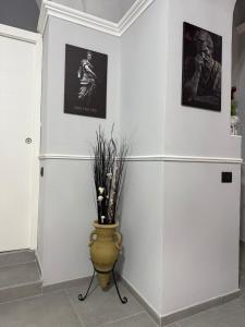 a room with white walls and a vase with flowers in it at CENTURIONI Alloggio turistico in Civitavecchia
