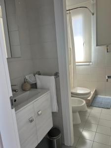 a white bathroom with a sink and a toilet at Classense House in Classe +18 photos