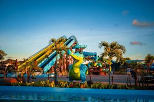 a water park with a roller coaster in the background at Flat Garden Açores Tamandaré Jardim Privativo Piscina Infinity in Tamandaré