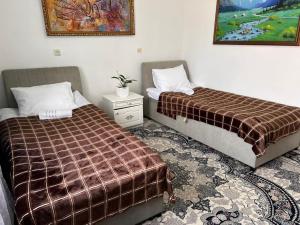 two beds sitting next to each other in a room at AJO Guesthouse in Naryn +26 photos