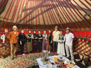 a group of people posing for a picture in a yurt at AJO Guesthouse in Naryn