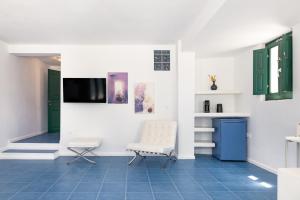a living room with a chair and a tv at Epic View Suites in Akrotiri