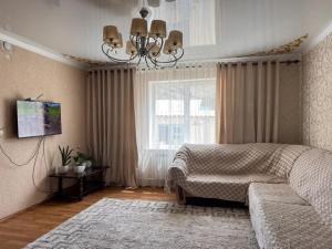 a bedroom with a bed and a couch and a window at AJO Guesthouse in Naryn