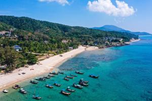 a group of boats in the water on a beach at Manao Seaview Pool Villa 33 - 5 Mins Walk To The Beach in Ko Lanta