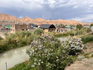 a city with a river and a town with mountains at AJO Guesthouse in Naryn