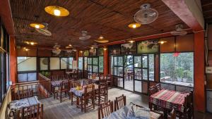 an empty restaurant with tables and chairs and windows at Ninh Binh Greenland Homestay in Ninh Binh
