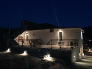 a white house with stairs and lights at night at Apartmani Vinko Palaversić in Jelsa
