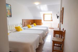a row of four beds in a room at Hotel Solatorre in Comillas