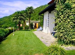 a garden with a house and a grass yard at Il Nido in Agra