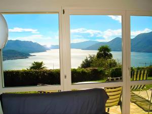 a room with a large window with a view of the water at Il Nido in Agra +4 photos