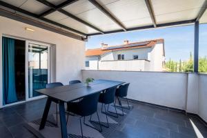 a table and chairs on the balcony of a house at Holiday Apartments Amarilis in Pakoštane