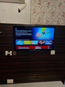 a flat screen tv hanging on a wall at RADHEY RADHEY stays in Vrindāvan