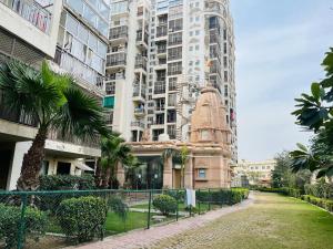 a building with palm trees and tall buildings at RADHEY RADHEY stays in Vrindāvan