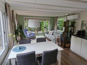 a kitchen and living room with a table and chairs at Nieuw chalet in Nunspeet in Nunspeet