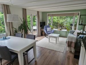 a living room with a table and a couch at Nieuw chalet in Nunspeet in Nunspeet