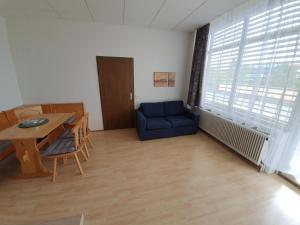 a living room with a blue couch and a table at Grössingblick in Zeltweg