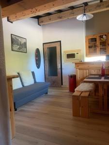 a living room with a blue couch and a table at Bouquetin studio cosy in Notre-Dame-de-Bellecombe +4 photos