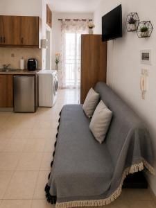 a living room with a couch and a kitchen at University Apartment in Heraklio