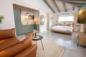 a living room with a couch and a bed at סוויטת דרים רויאל - סוויטה חלומית עם אמבט ספא מפנק ונוף מדהים in ‘Ein Ya‘aqov +23 photos