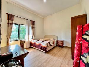 a bedroom with a bed and a desk and a window at MP Villa Tirta Sevil S3 Malang in Mantaak +45 photos