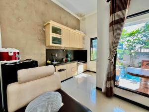a living room with a couch and a kitchen at MP Villa Tirta Sevil S3 Malang in Mantaak