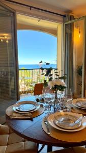 a table with plates and glasses on top of it at Riviera Heights Monaco in Beausoleil