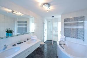a bathroom with a tub and a sink and a toilet at Hotel Penz West in Innsbruck