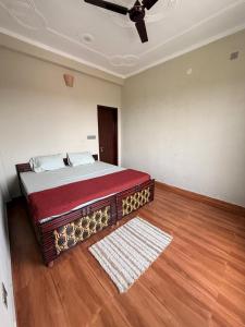 a bedroom with a bed and a ceiling fan at Aahista Stays- Mountain view homestay in Bīr +12 photos