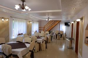 a room with tables and chairs and a staircase at Cabana Sargetia in Costeşti