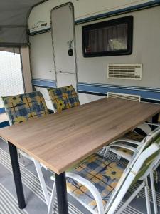 a wooden table and chairs in an rv at Túrkeve Lakó in Túrkeve