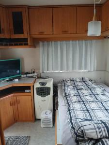 a small room with a bed and a desk with a computer at Túrkeve Lakó in Túrkeve