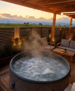 a large hot tub on a deck with a sunset at בריאה אירוח בטבע in Sha'al