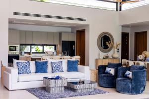 a living room with a white couch and blue chairs at Botanica Foresta Luxury Villa Phuket in Phuket