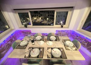 a dining room with a table with plates and glasses at Attico di Cesare Luxury Piazza Anfiteatro Lucca in Lucca