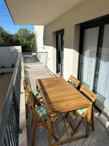 a wooden table and chairs on a balcony at Suarina in Porto-Vecchio