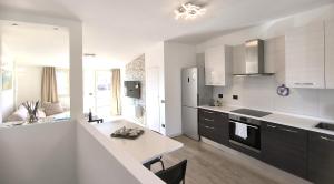 a kitchen with white cabinets and a white counter top at Attico di Cesare Luxury Piazza Anfiteatro Lucca in Lucca
