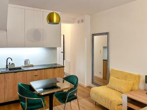 a kitchen and a living room with a table and a couch at Nowy Dwór Mazowiecki Chic Studio by BookingHost in Nowy Dwór Mazowiecki