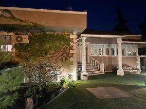 a large house with a porch and stairs at night at Espaciosa villa con piscina, ideal para relajarse en familia in Los Hueros