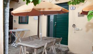 a wooden table with an umbrella next to a door at Agriturismofaucci in Campo nell'Elba