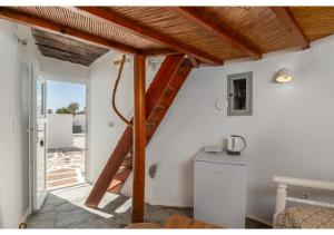 a room with a staircase and a kitchen with a table at WindMilos in Tripiti