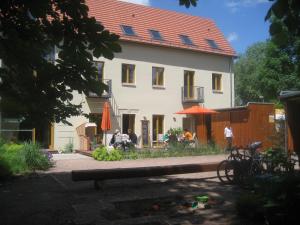 ein Haus mit einer Bank davor in der Unterkunft Bio Hotel Kipperquelle in Weimar