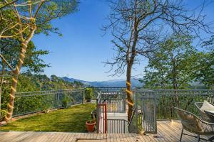 a deck with a view of the mountains at Oak Villa in Dharampur +21 photos