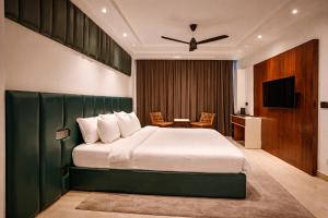a bedroom with a large bed and a television at Oak Villa in Dharampur