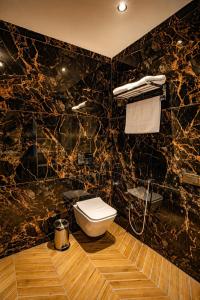 a black marble bathroom with a toilet and a shower at Oak Villa in Dharampur
