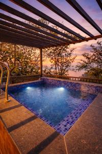 a swimming pool with a pergola and a swimming poolvisor at Oak Villa in Dharampur