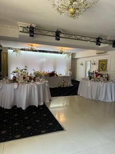 a banquet hall with two tables with white tablecloths at Mayak Resort in Kam”yani Potoky +86 photos
